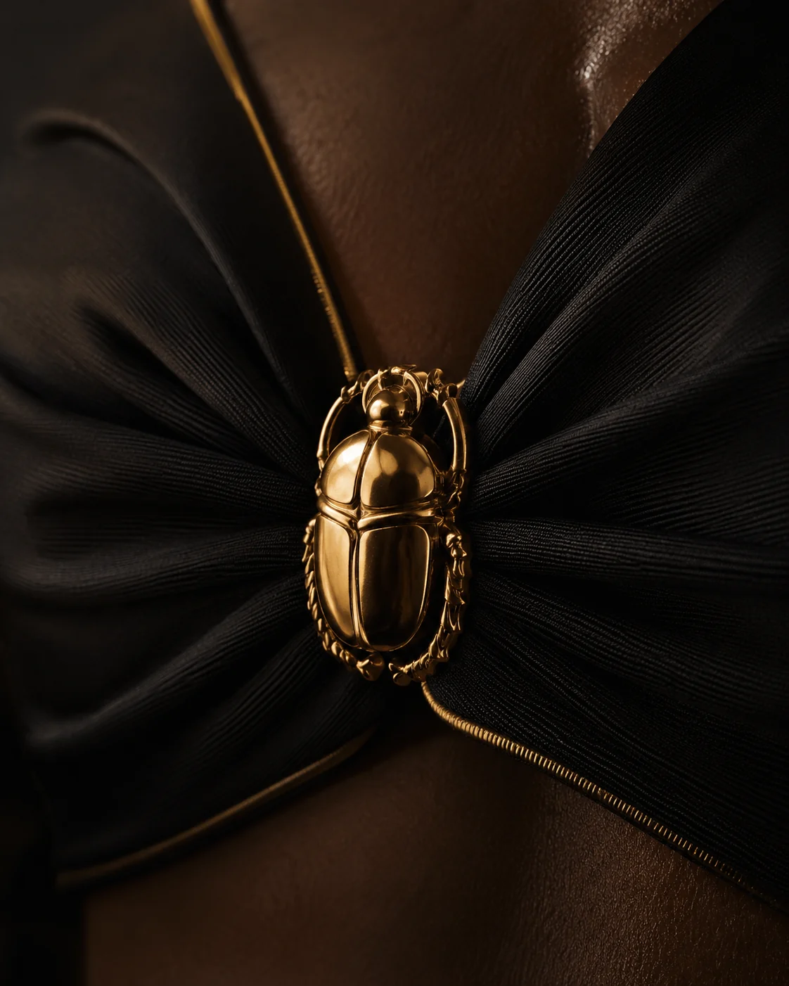 Gold scarab detail on black fabric